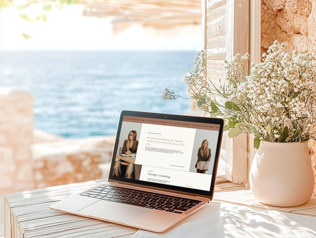 Laptop on a table displaying Squarespace website template for coaches with a scenic view of the ocean through a window.